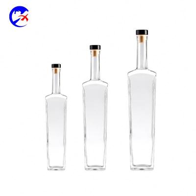 China Clear Beverage Wine Glass Bottle Vodka 700ml Liquor Bottle With Weight Cork Customized Whiskey Bottle for sale