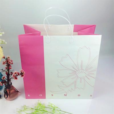 China Clothing Shoes Gift Packaging High Quality Flower Printing Kraft Paper Bag Women Clothes Shopping Bag With Plastic Handle Carry for sale