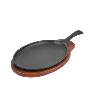 China Wholesale Stocked Oval Cast Iron Skillet Sizzling BBQ Beef Tray With Wooden Base for sale