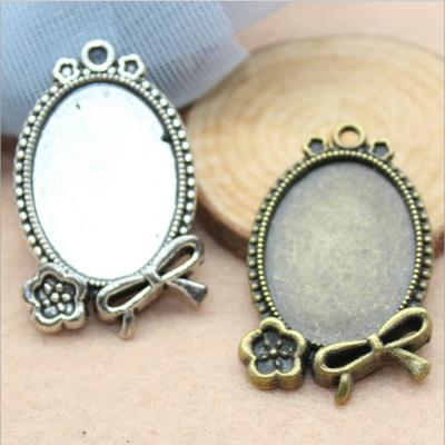 China Eco Friendly Explosive Border Flower Bowknot Oval Base Setting Metal Necklace Pendant White For Jewelery for sale