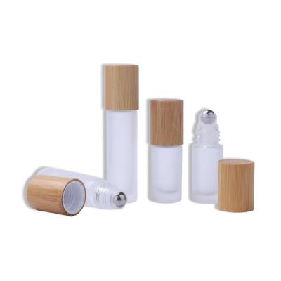 China 5ml 10ml Cosmetic Essential Oil Clear Frosted Refillable Glass Roll On Bottle With Steel Trackball And Bamboo Cap for sale