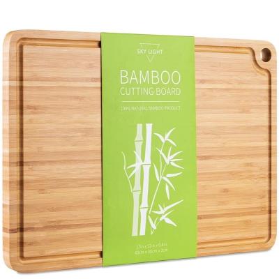 China Sustainable Bamboo Wooden Cutting Board With Grooved Meat And Cheese Cutting Board With Hanging Holes for sale