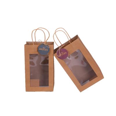 China Brown Recyclable Cosmetic Gift Wrapping Paper Bag With Round Gift Tag Clear Window Twisted Kraft Paper Handles for sale