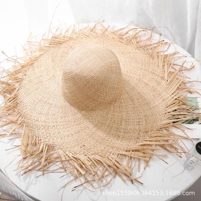 China Sunproof Fashion Vacation Travel Wide Brim With Ribbon Sun Beach Hats 100% Hand Weave Natural Raffia Fringed Straw Hat for sale