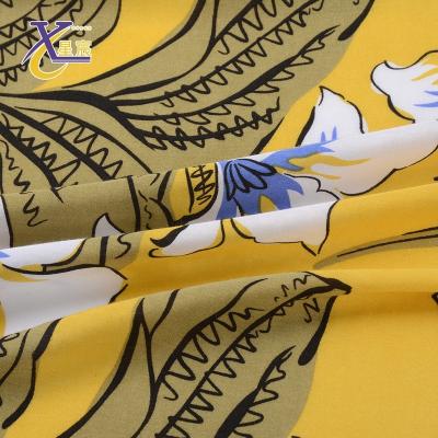 China Xingchen Good Quality Garment Material Lots Classic Viable Stock Bright Yellow Floral Rayon Printed Woven Fabric for sale