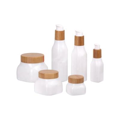 China Luxury design cosmetic 40ml 100ml 120ml and 50g 150g 250g cream porcelain glass bottle white jar set with bamboo cap for sale