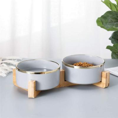 China Sustainable New Arrival Luxury Gray Gold Double Edged Color Ceramic Round Pet Bowl With Wooden Stand for sale