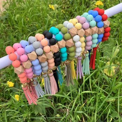 China Hot Selling Silicone Beaded Bracelet Silicone Key Chain Colorful Wooden Beaded Silicone Matching PU Leather Tassel for Women Car and Bag Bracelet Key Chain for sale