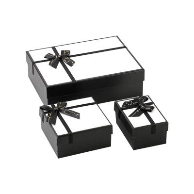 China Caja de tapa de regalo de papel blanco y negro con logotipo personalizado e impresión de cinta en venta