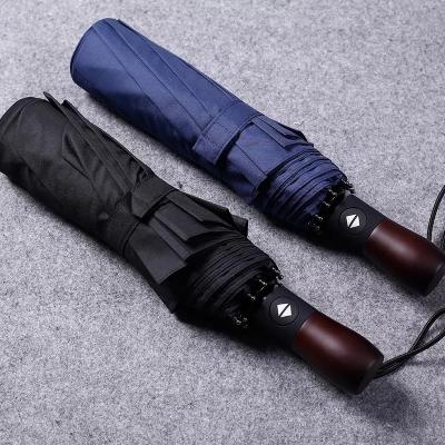 China Fully Automatic 10 Ribs Wind Resistant Solid Wood Handle Engraved with Three Fold Men's Business Umbrella for sale