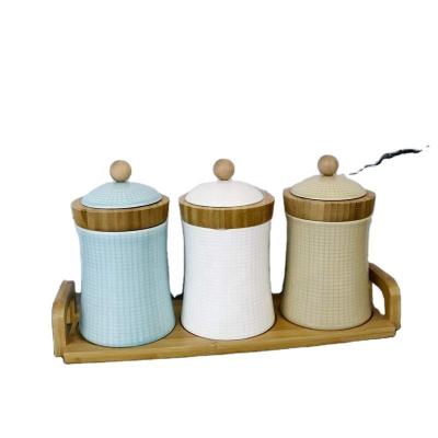 China Sustainable Set of 4 Ceramic Seasoning Rack Jars Bowls with Spoon Cover Storage Container Bamboo Condiment Jars Spice Sets Porcelain for sale