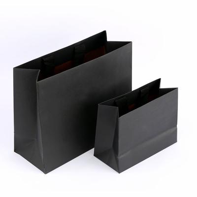 China Recyclable Recycled Paper Bag With Ribbon Handle Stamping Foil Stamping Logo Printing Black Gift Garments Paper Bag Packaging Wholesale for sale