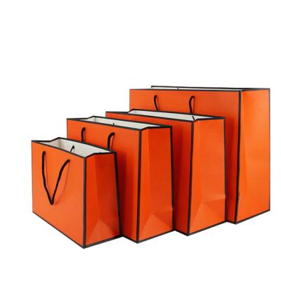 China Recyclable Hot White Orange Black Portable Clothing Paper Bag White Orange Black Stain Hand Luxury Paper Bag Selling Spot Paper Bag for sale