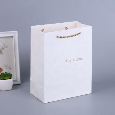 China Recyclable luxury custom paper apparel bag personalized eco-friendly white gold foil apparel paper bag with brand logo for sale