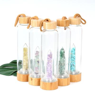 China Round Glass Water Bottle With Natural Crystal Gemstone Center Elixir Crystal Point for sale