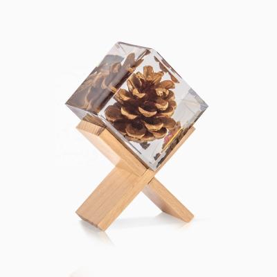 China Real Nice Pine Cone Cube Shaped Resin Decoration With Wooden Stand for sale