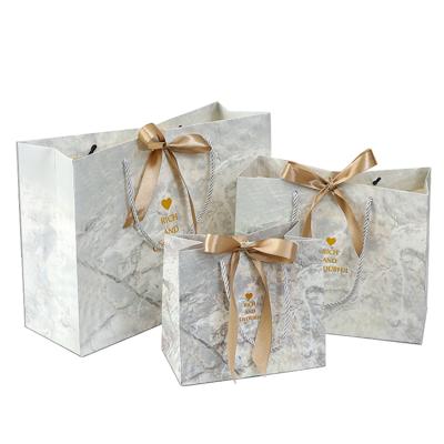 China Handmade wholesale marble paper bag with ribbon bow tie printed logo shopping paper bags for clothing for sale