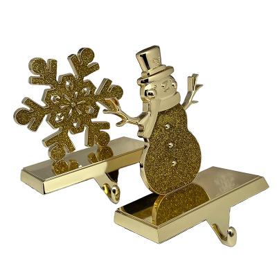 China Christmas Day Decoratiom Gold Snowflake and Snowman Stocking Hanger for Mantel Christmas Stocking Holders Mantel Hooks Hanger for Christmas Party for sale