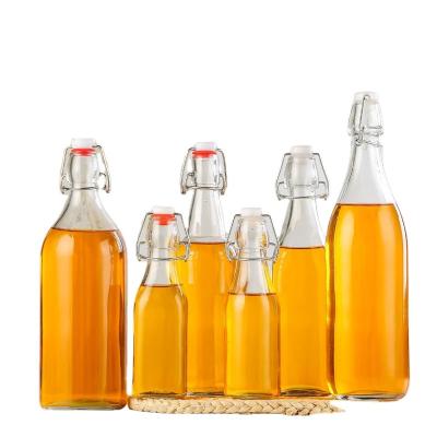 China Food Top Selling 250ml 500ml 750ml 1000ml Empty Glass Bottle With Easy Swing Snap Cap For Beverage Juice Beer Vodka Whiskey Oil for sale