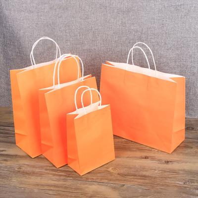 China Wholesale Custom Fashion Eco - Friendly Orange Recyclable Clothes Dress Gift Shopping Kraft Paper Bag With Handle for sale