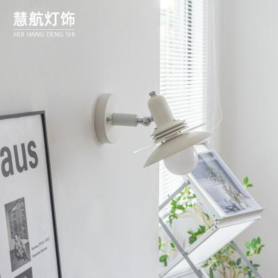 China HUIHANG Latest Interior Design Cream Iron Painting Bedroom Bedside Modern Warm Light Hotel Led Wall Lamp for sale