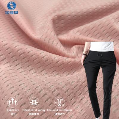 China Stain Repellent Jacquard warp knitted fabric 84Nylon16 Spandex elastic fabric knitted solid mesh breathable bird eye casual pants fabric for sale