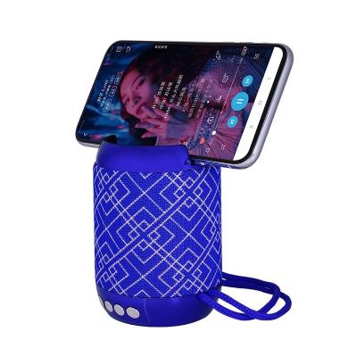 China Mini Portatil Altavoz Usb Fm Stereo Portable Wireless Car Cloth Fabric 5w Wireless Speaker With Cell Phone Holder for sale