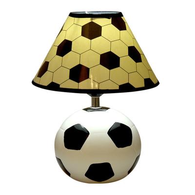 China Modern Creative indoor designer modern smart soccer table lamp PVC shade desk light resin football shaped table lamp for sale