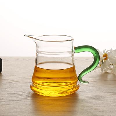 China 300ml Stocked Thickened Tea Cup Glass Crescent Glass Fair Mug With Green Handle for sale