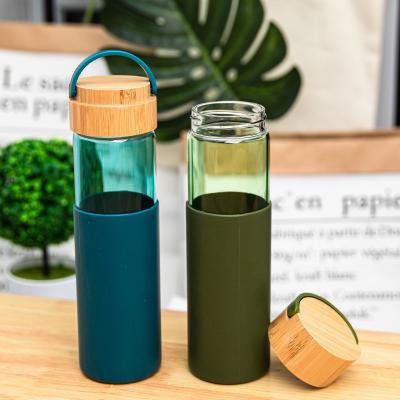 China Wholesale Sustainable Drinking Glass 550ml Water Bottle With Silicone And Bamboo Sleeve Lid for sale