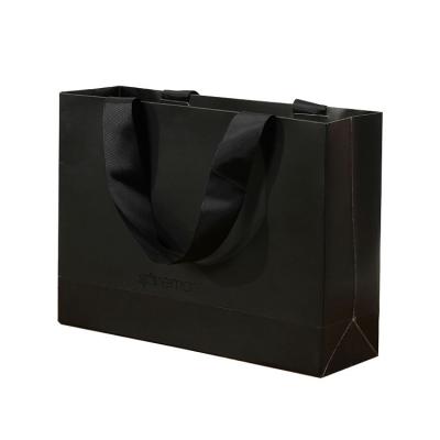 China Recycled Materials Personality Custom Printed Black Luxury Brand Clothing Retail Packaging Paper Bag With Logo for sale