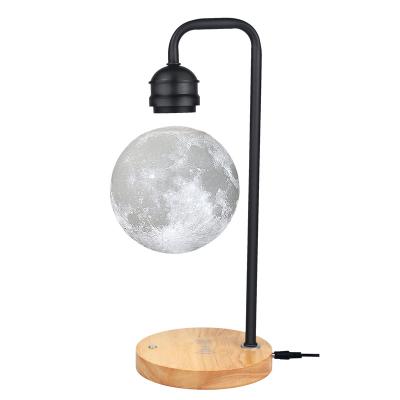 China Magnetic levitation post-modern moon shaped lamp base with wireless charging mobile phone base has touch switch control bulb for sale