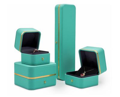 China With Hot Luxury Green Leather Jewelery Boxes Ring Necklace PU Ring Gift Decor Metal Button Jewelery Packaging Box With Gold Band for sale