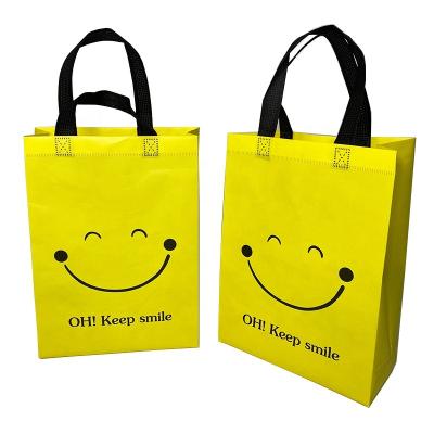 China Handled Spot Thicken Film Laminated Non-woven Bag Cute Yellow Smiley Children's Hand-held Shopping Bag Clothing Bag Children's Shoes Pac for sale