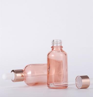 China Custom Empty Personal Care Essential Oil Rose Gold Frosted Clear Glass Circular Dropper Bottle for sale