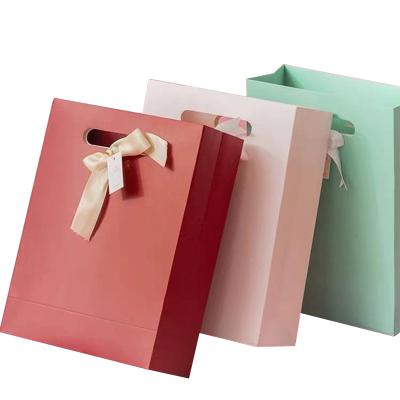 China Recycled Materials Custom Printed Christmas Gift Paper Bag Handmade Luxury Cardboard Rose Simple Sealing Bag for sale