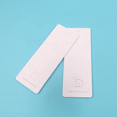 China OEM Viable Design Customized Round Corner Matte White Cardboard Dresses Paper Hang Tags with Luxury Rose Gold Stamp Main Logo for sale