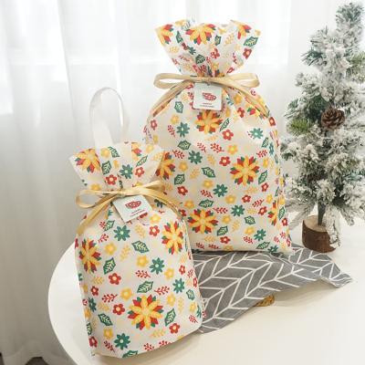 China Disposable Nonwoven Drawstring Gift Pouches Christmas Party Decorated Candy Bag Gift Bag for sale