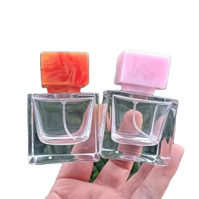 China Custom Glass Perfume Bottles Cosmetic Perfume Glass Bottles Glass Bottle 100ml Scrap Resin Cap for sale