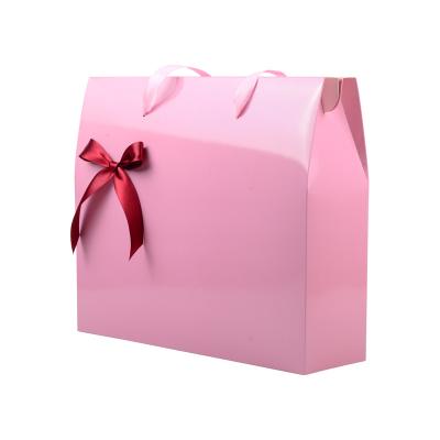 China Handmade High Quality Custom Pink Printing Paper Package Bag With Ribbon Handle for sale