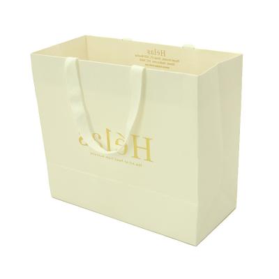 China Recyclable Gold Stamping Logo Luxury White Matte Kraft Hot Foiling Paper Bag With Cotton Rope Ribbon Handles for sale