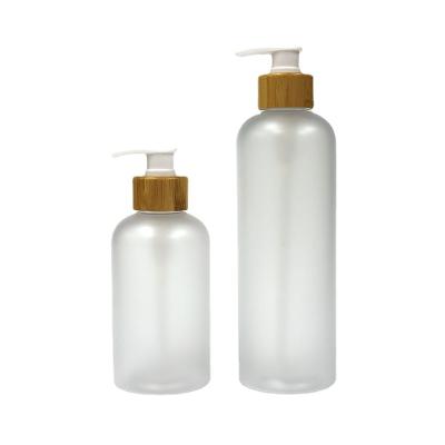 China 300ml 500ml 10oz 17oz Boston Round Cosmetic Matte Frosted Plastic Bottle With Bamboo Pump For Shampoo Liquid Soap for sale