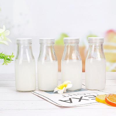 China High Quality Beverage Round Glass Beverage Bottles Glass Milk Bottle With Plastic Lid for sale