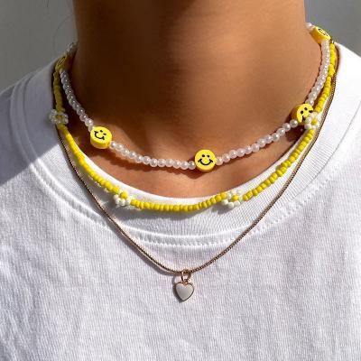 China FASHIONABLE Multilayer Yellow Acrylic Flower Necklace for Seed Pearl Smile Face White Love Heart Pearl Chain Necklace for sale