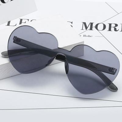 China 2021 European Style Fashion Rimless Love Sunglasses Women One Piece Lens Candy Color Heart Shape Sunglasses Without Nose Pads for sale