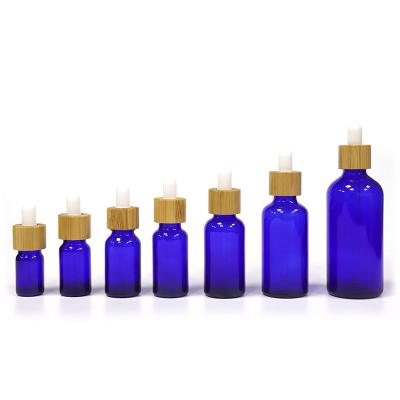 China Cosmetic Blue Glass Dropper Bottle Vial 5ml 100ml Dropper Bottles Perfume Essential Oils Refillable Bottles With Wood Grain Cover for sale