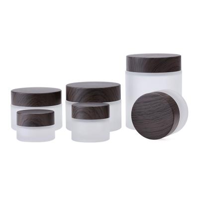 China 1oz Empty Refillable Frosted Glass Cosmetic Jar 5g 10g Face Cream Jar 100g Travel Sample Jar With Wood Grain Cover for sale