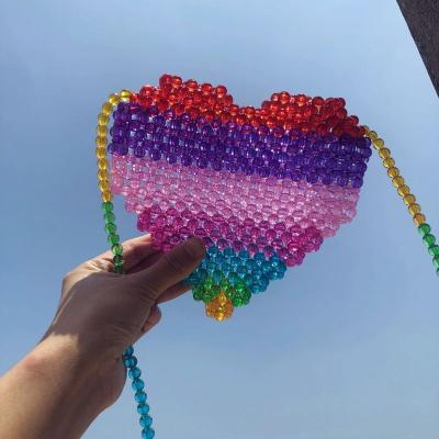 China Fashion ins the same handmade beaded heart-shaped paragraph rainbow package 2021 new contrast color woven cross-body travel bag for sale