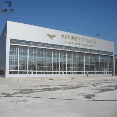 China Large Modern Industrial Insulated Sliding Folding Hangar Door With Bottom Rails for sale