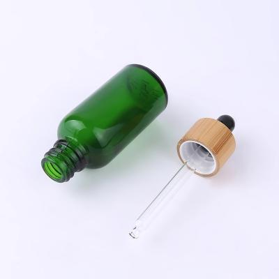 China 30 50 100 ml cosmetic frosted hair oil glass green cosmetic bottle with bamboo dropper for sale